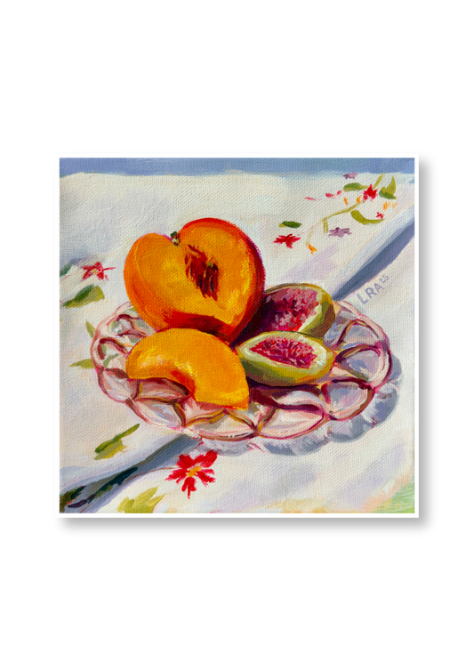 Sliced peaches and figs on a decorative plate with a floral tablecloth
