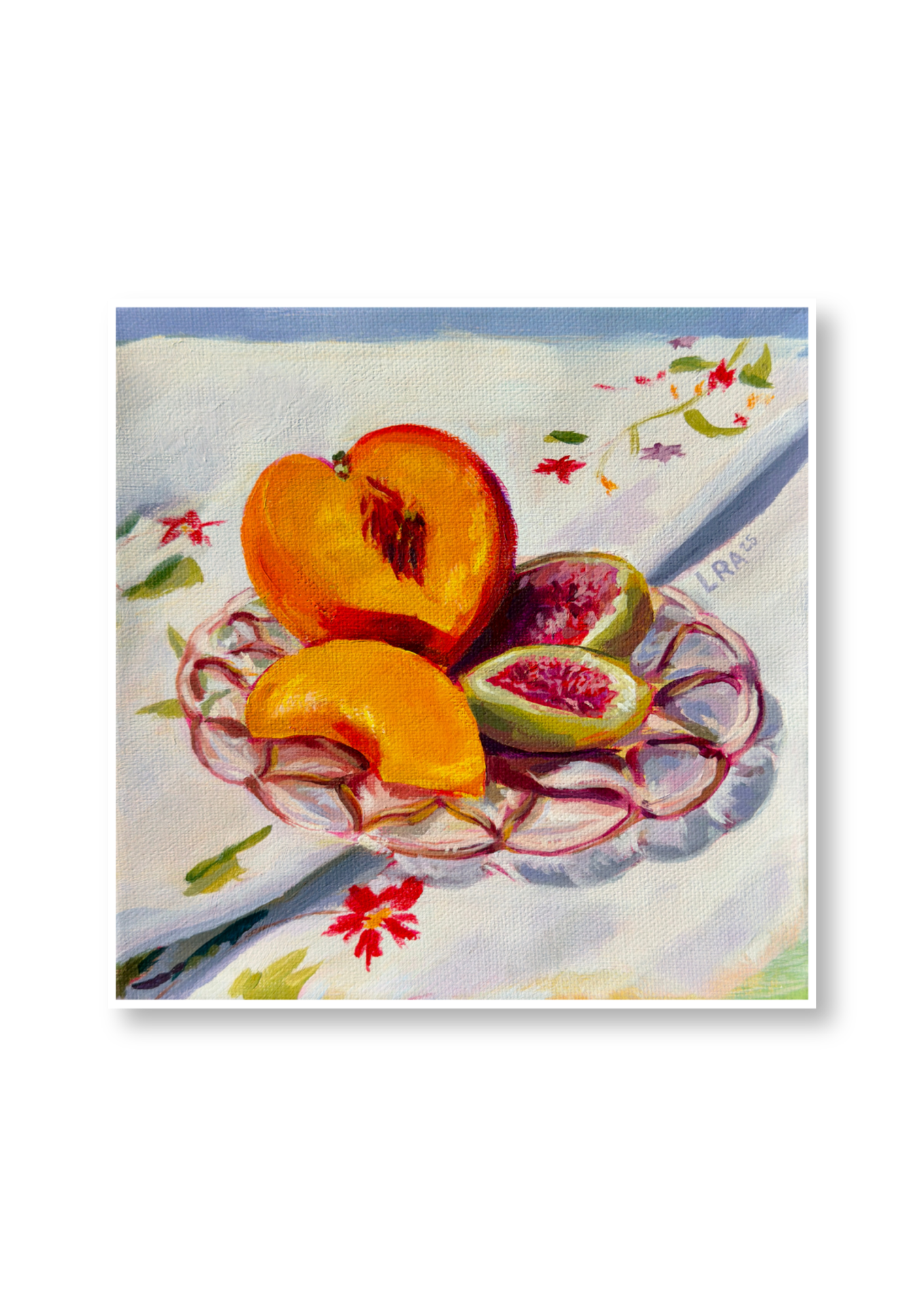 Sliced peaches and figs on a decorative plate with a floral tablecloth
